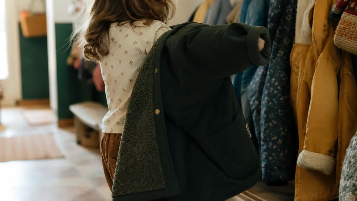Un enfant apprend à mettre son manteau au quotidien