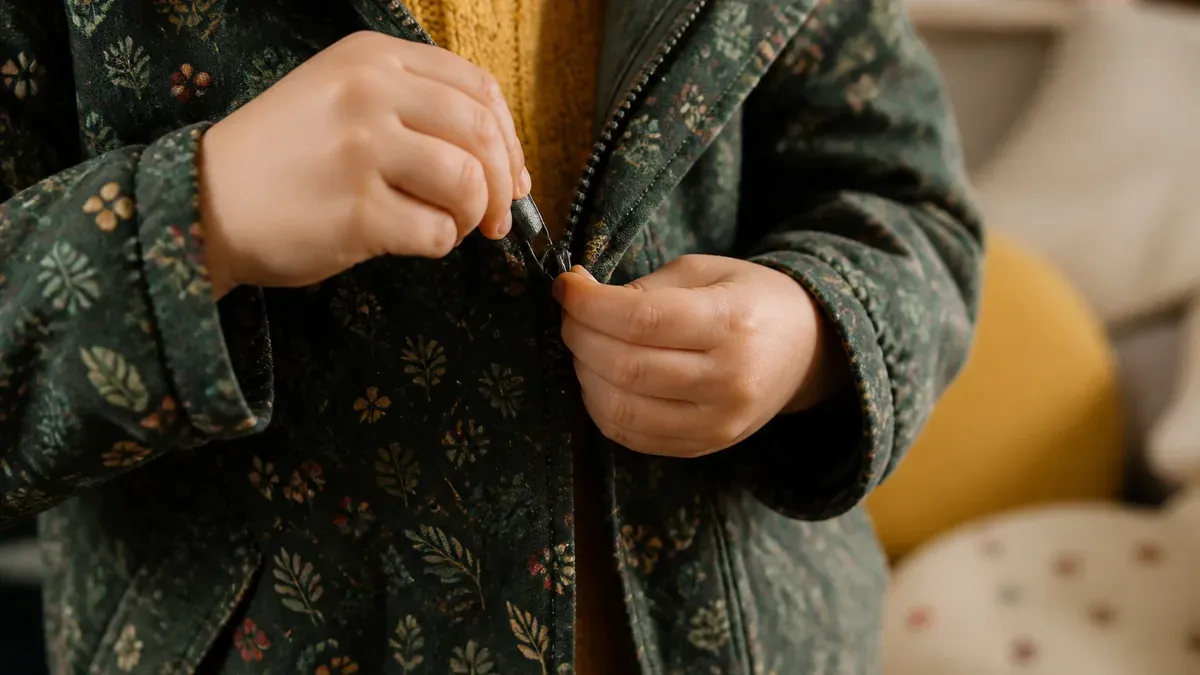 Un enfant apprend à fermer sa fermeture éclair pas à pas